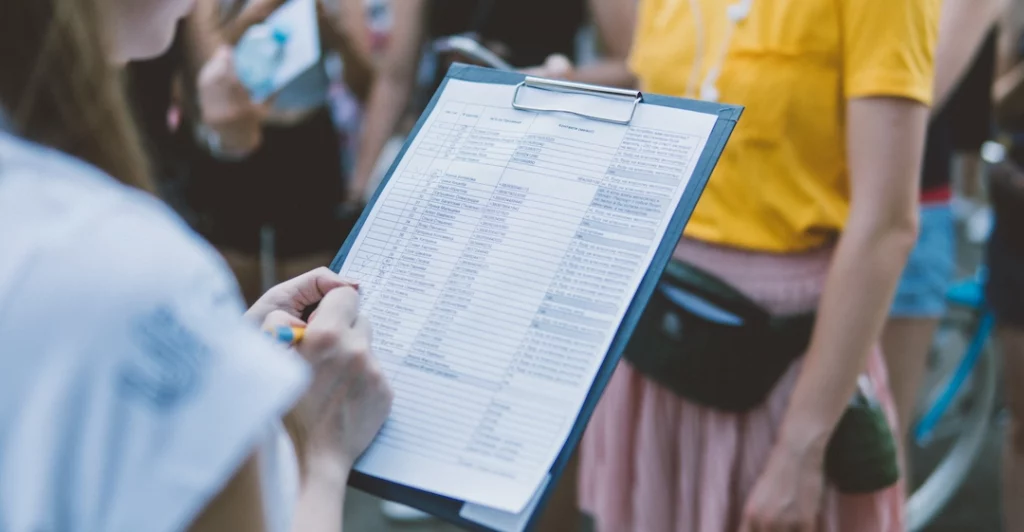 Une femme tiens dans ses mains une checklist de points à évaluer